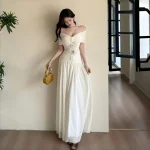 Ivory off-shoulder lace-panel maxi dress, full-length by the window